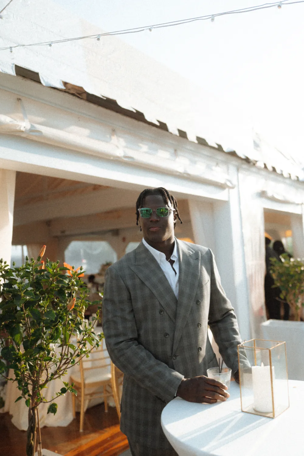 An NFL client in a grey check double breasted suit at a reception.